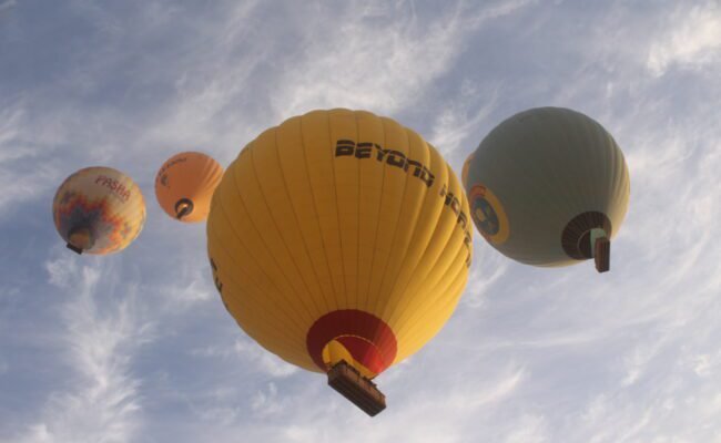 Colorful hot air balloons flying over Luxor Egypt at sunrise above the Nile River and ancient temples