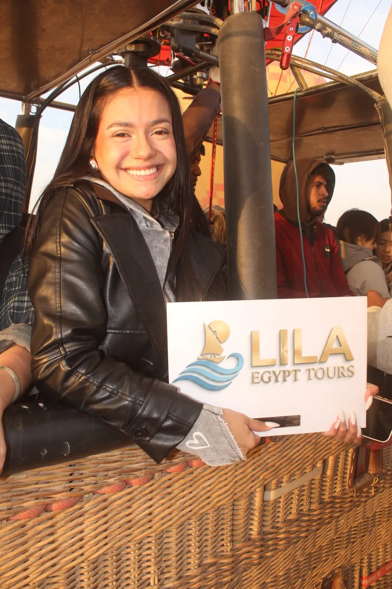 A Lila Egypt Tours traveller in a hot air balloon basket at sunrise over Luxor