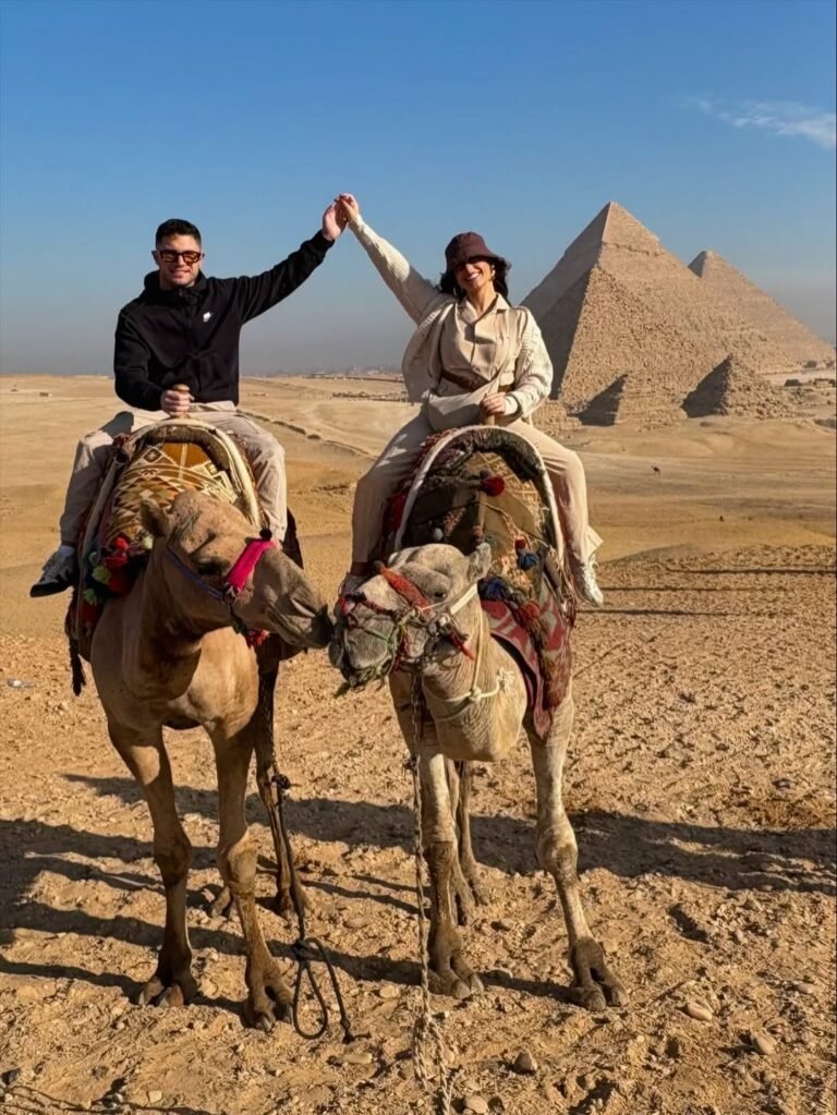 Couple on camels in front of the Giza Pyramids