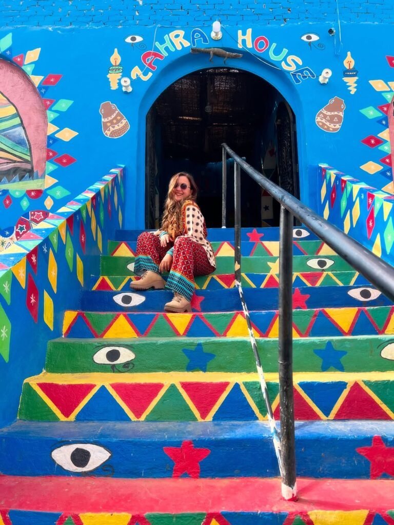 Visitor on the painted steps of a Nubian house