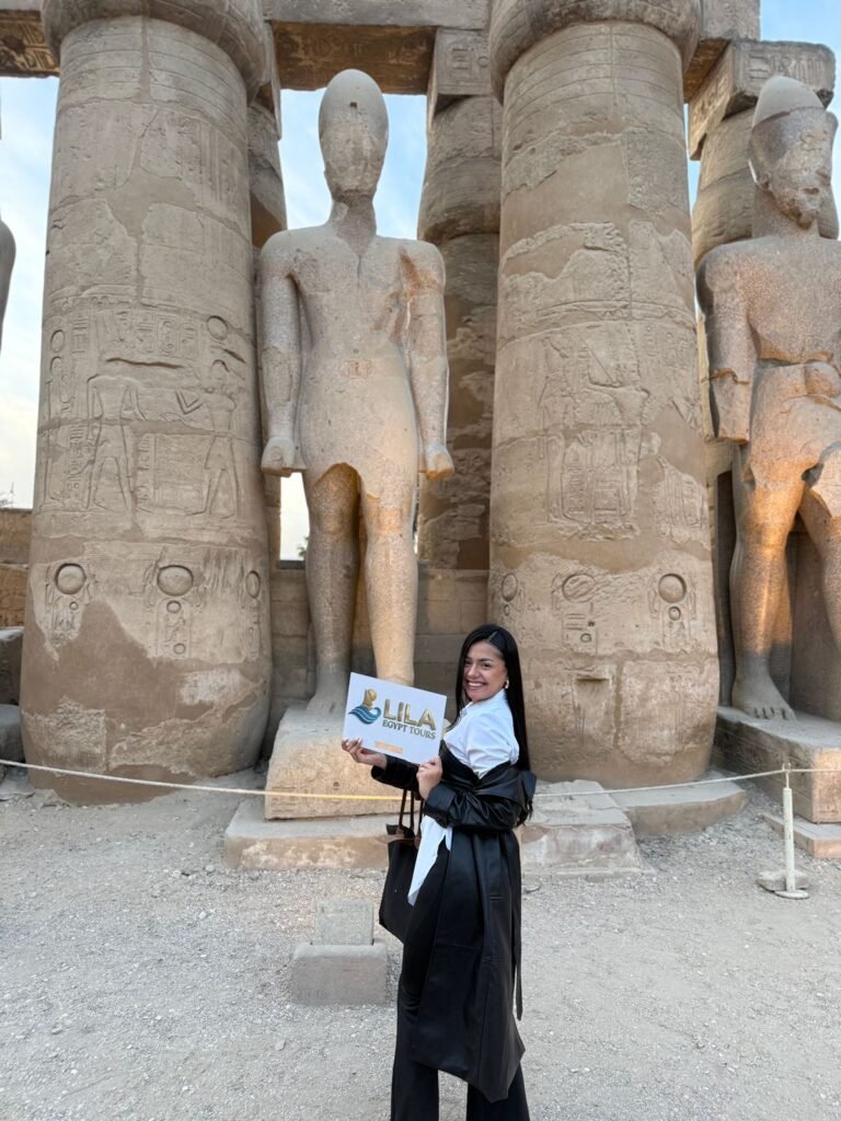 Visitor in front of colossal statues of Ramses II