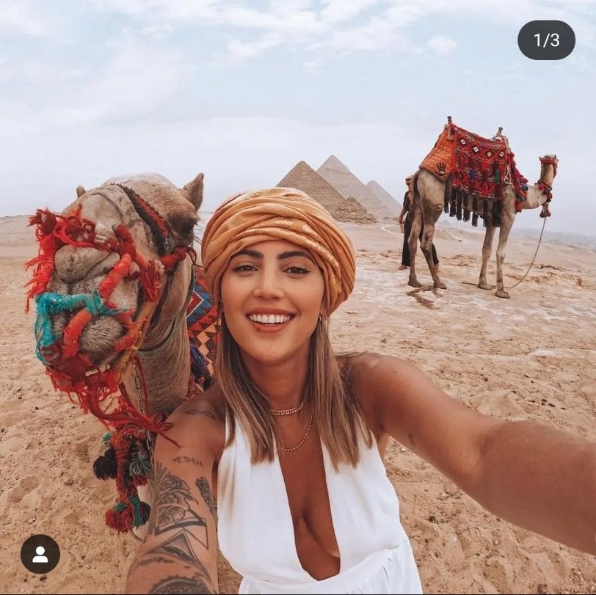 A traveller with camels in front of the Giza pyramids on a private Cairo tour