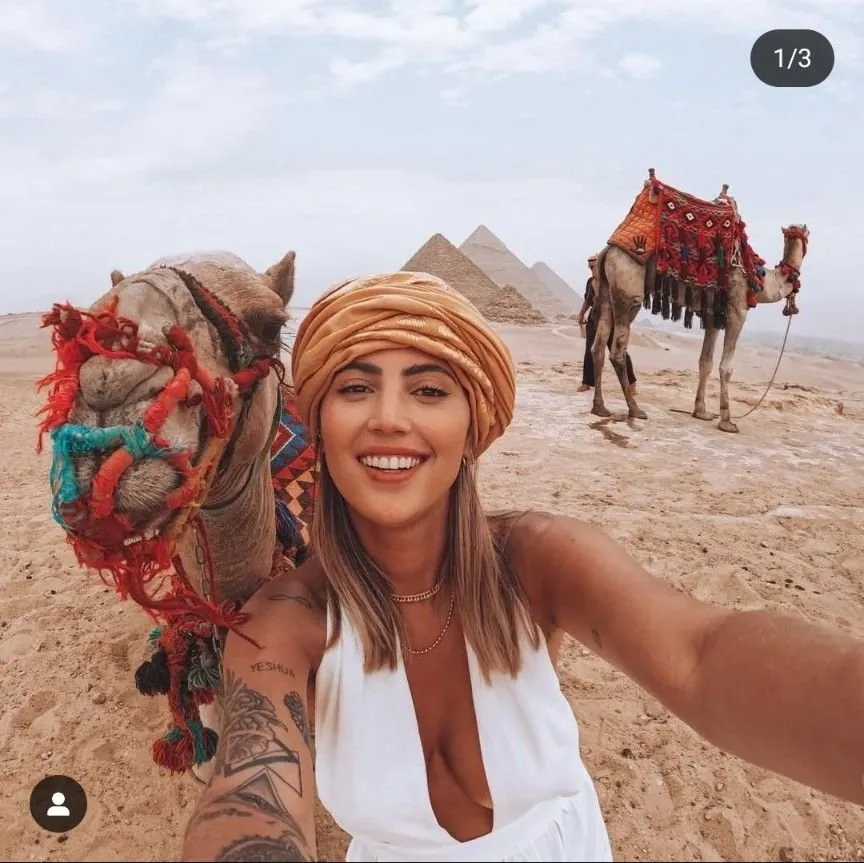 A traveller with camels in front of the Giza pyramids on a private Cairo tour